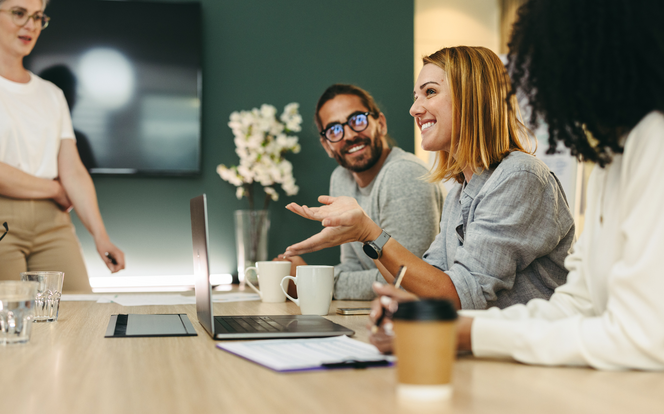 Business woman talking to her colleagues during a meeting in a boardroom Retained Solution